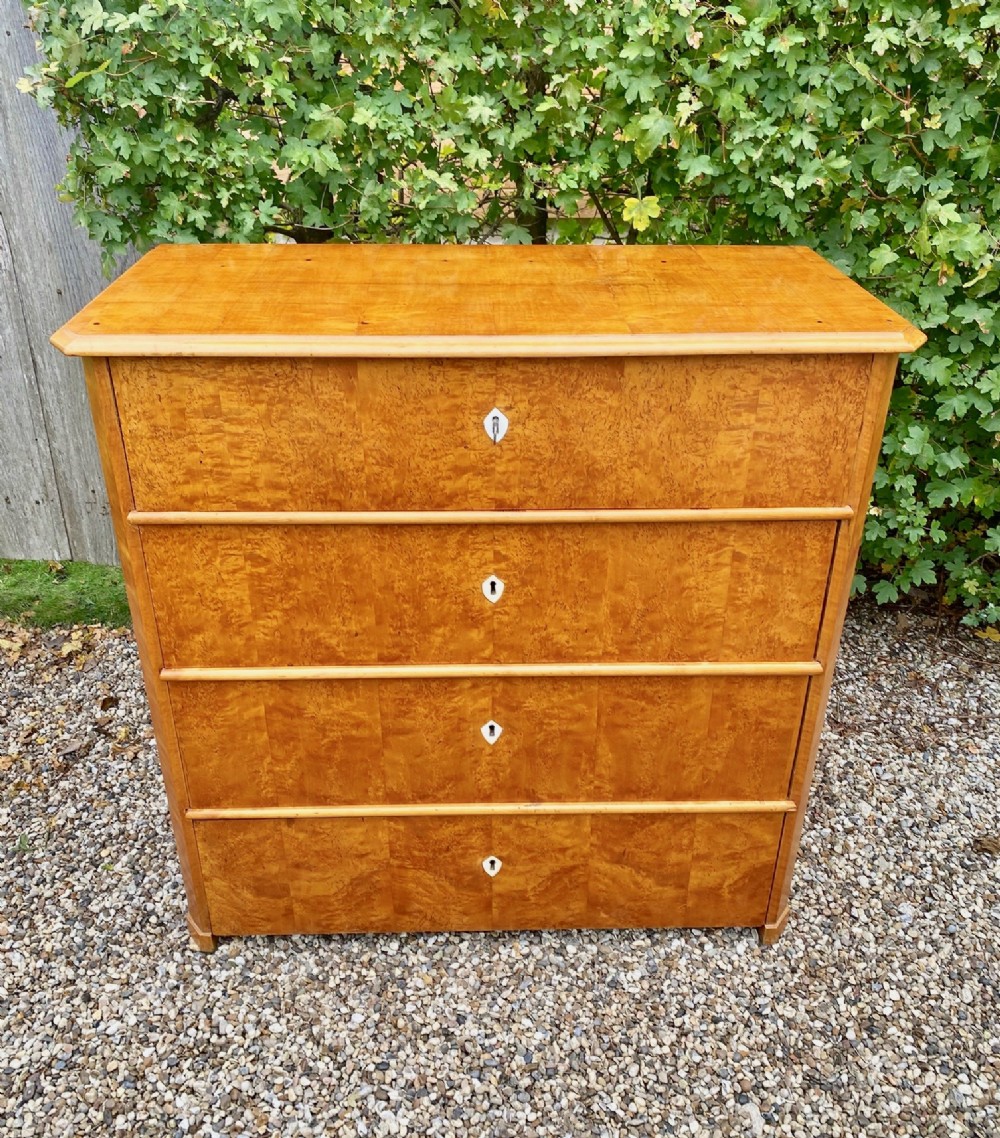 A mid-19th-century Swedish satin birch chest featuring four straight drawers with central keyhole escutcheons. View V
