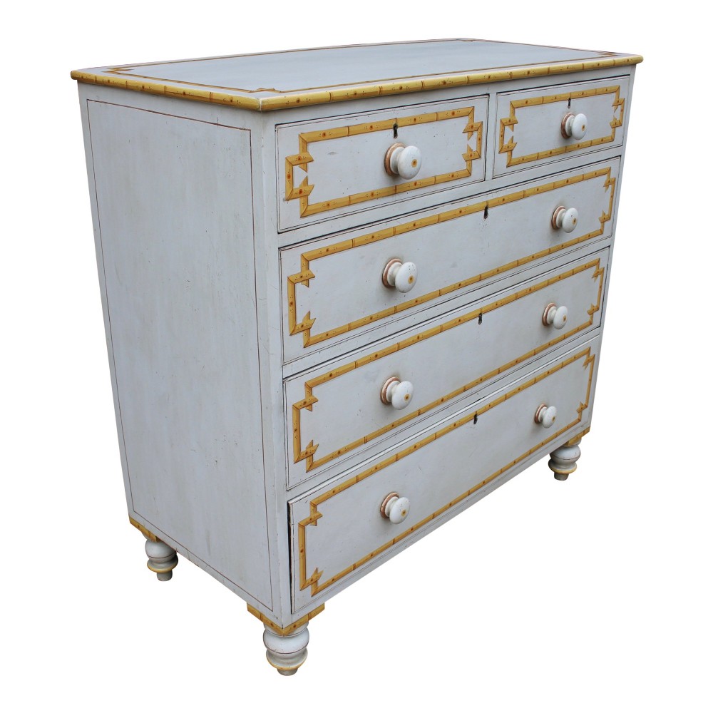 A nineteenth-century off-white painted chest of drawers featuring decorative yellow faux bamboo borders, wooden knobs, and turned feet. View III