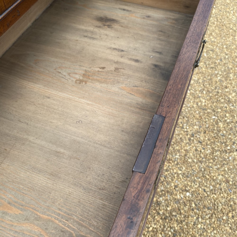 A tall George II walnut chest of drawers featuring figured veneer drawer fronts, brass keyhole escutcheons, brass handles, and bracket feet. View VI
