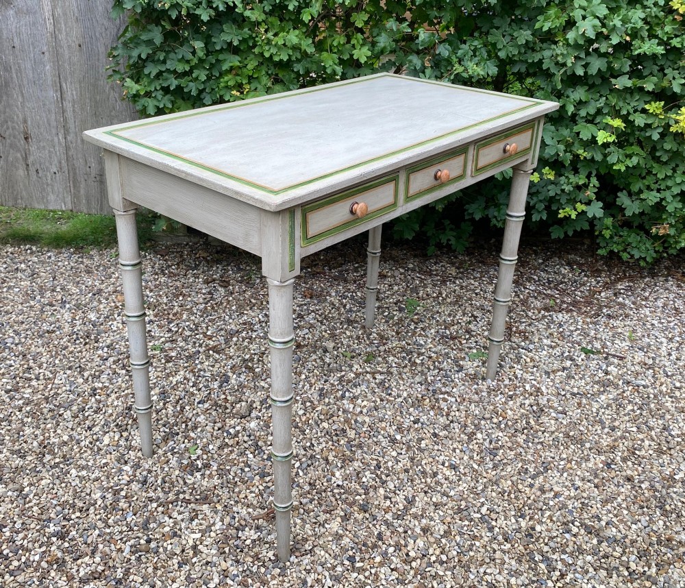 A light grey painted Regency side table featuring green border lining, three drawers with turned wooden knobs, and four legs shaped like bamboo. View II