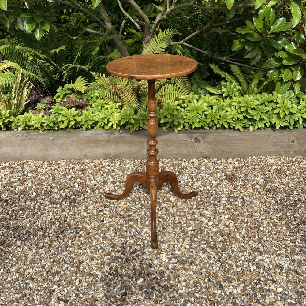 An 18th-century George II walnut wine table featuring a circular top, a baluster-turned central column, and a three-legged tripod base.