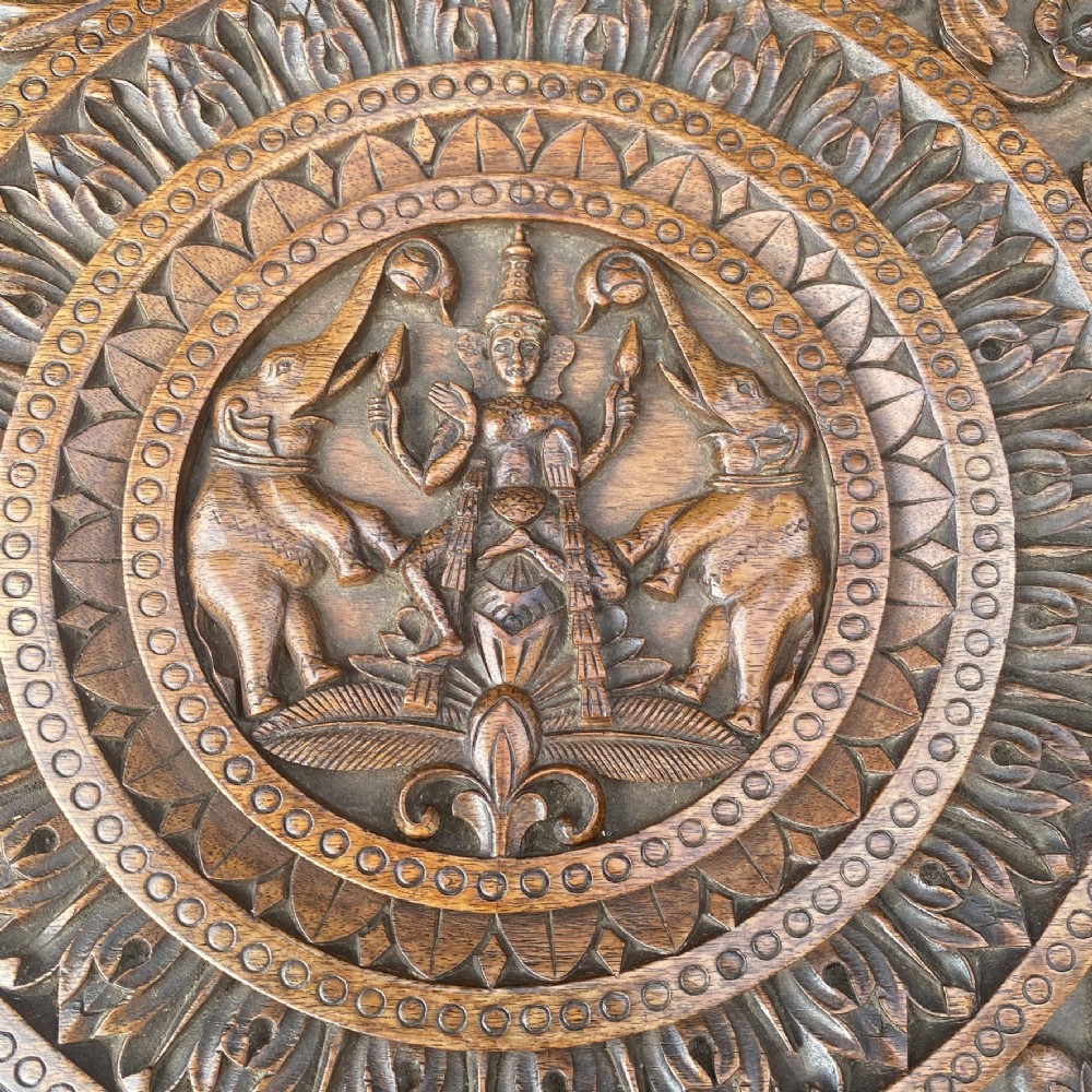 A circular carved rosewood side table supported by three legs shaped as detailed elephant heads with trunks extending to the floor. View IV
