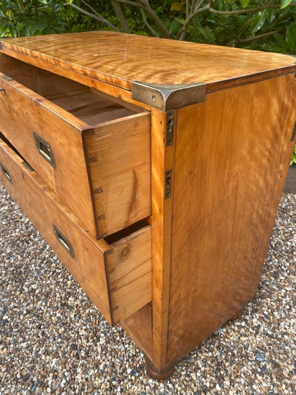 A mid-19th-century satin birch military campaign chest featuring three full-width drawers with flush recessed brass handles and corner brass protective brackets. View III