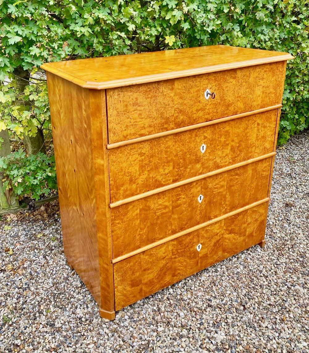 A mid-19th-century Swedish satin birch chest featuring four horizontal straight drawers with diamond-shaped white keyhole escutcheons. View II