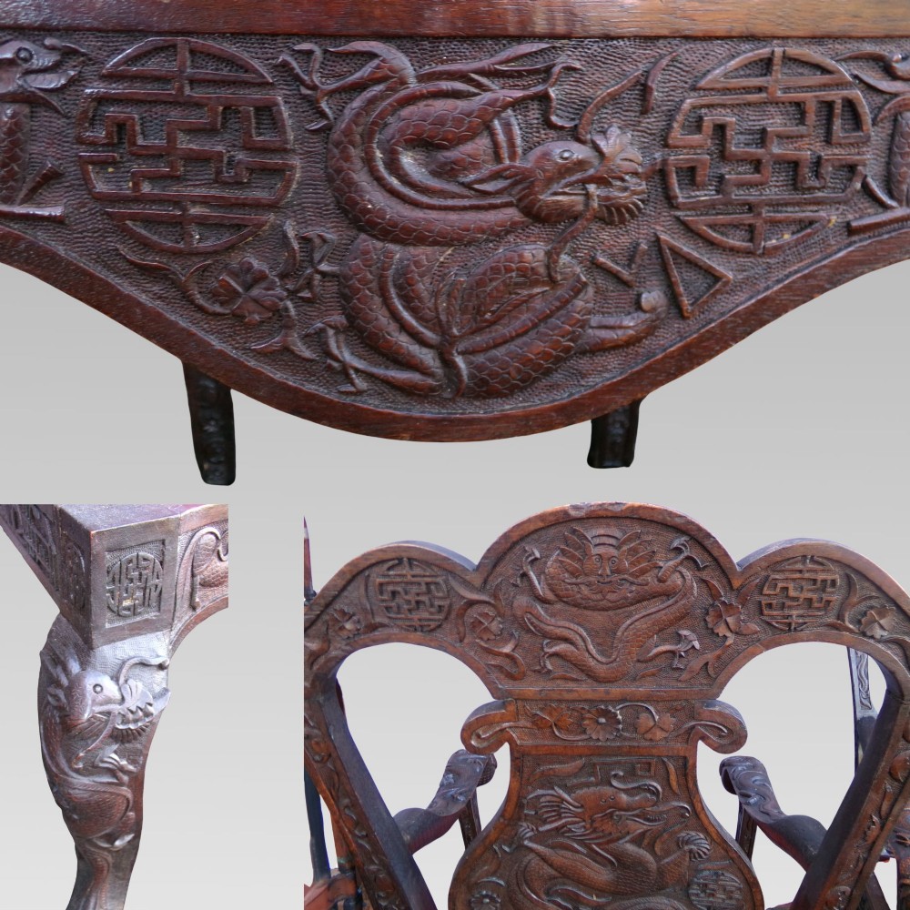 A pair of dark carved hardwood armchairs featuring high back splats with dragon relief motifs, dragon head terminal arms, and red upholstered seats. View V