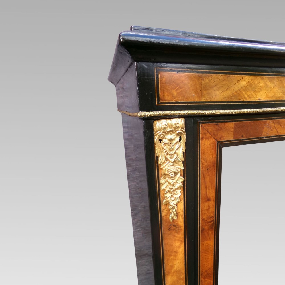 A 19th-century Victorian walnut and ebonised display cabinet featuring two glazed doors, gilt metal mounts, and a magenta velvet interior. View IV