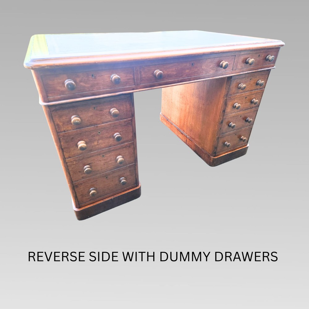 A Victorian oak pedestal writing desk featuring a green leather inset top and multiple drawers with turned wooden handles. View XI