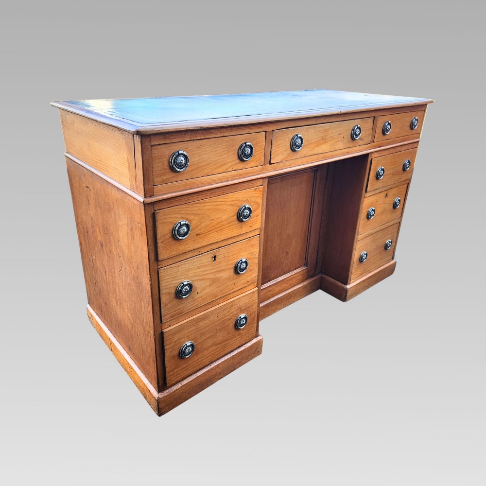 An antique Victorian pine pedestal writing desk featuring a green leather inset top and twin pedestals fitted with drawers and brass ring handles. View II