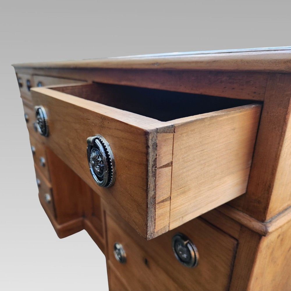 An antique Victorian pine pedestal writing desk featuring a green leather inset top and twin pedestals fitted with drawers and brass ring handles. View IV