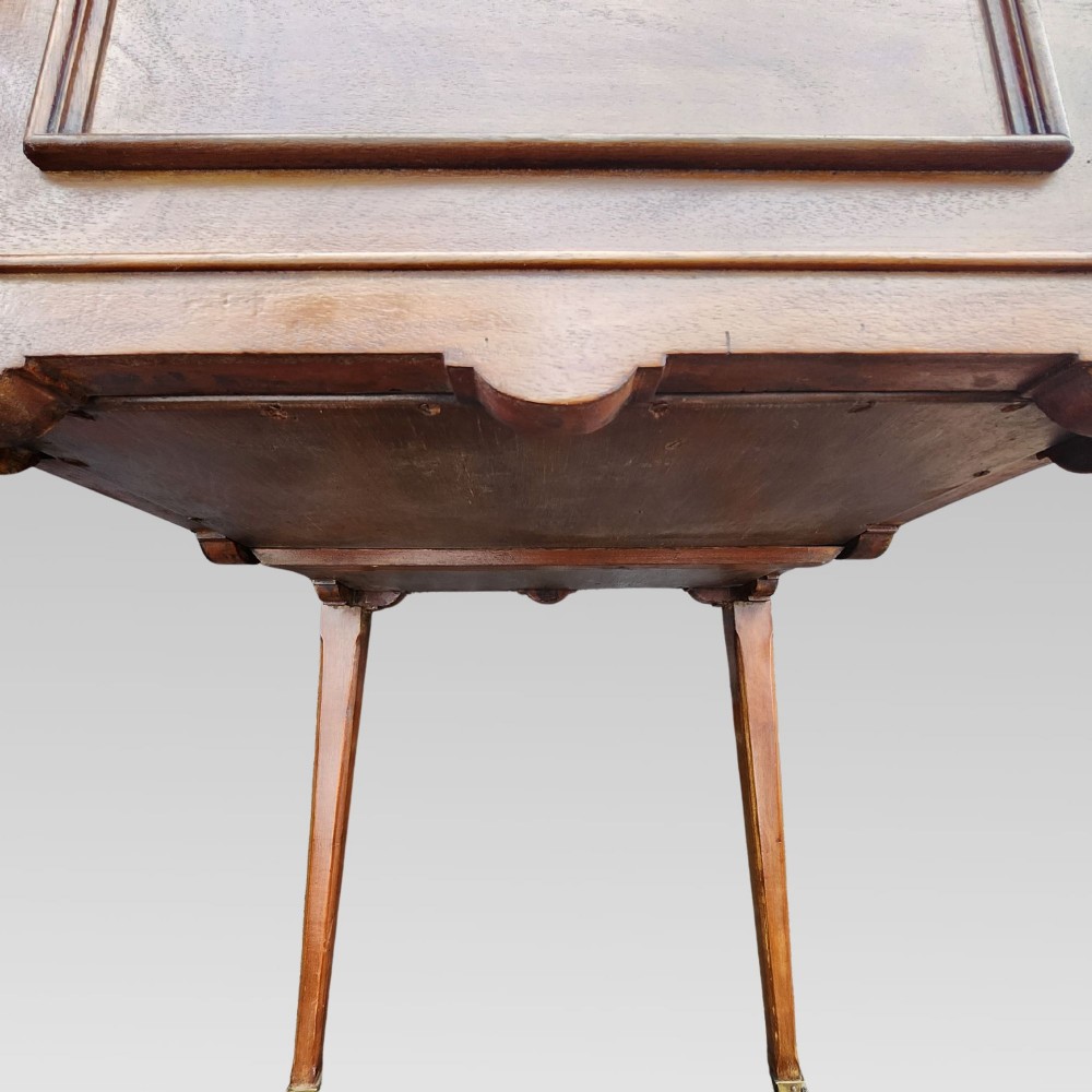 An open antique Edwardian mahogany metamorphic writing desk featuring fold-out side flaps, a green leather writing surface, integrated inkwells, and brass fittings. View IX