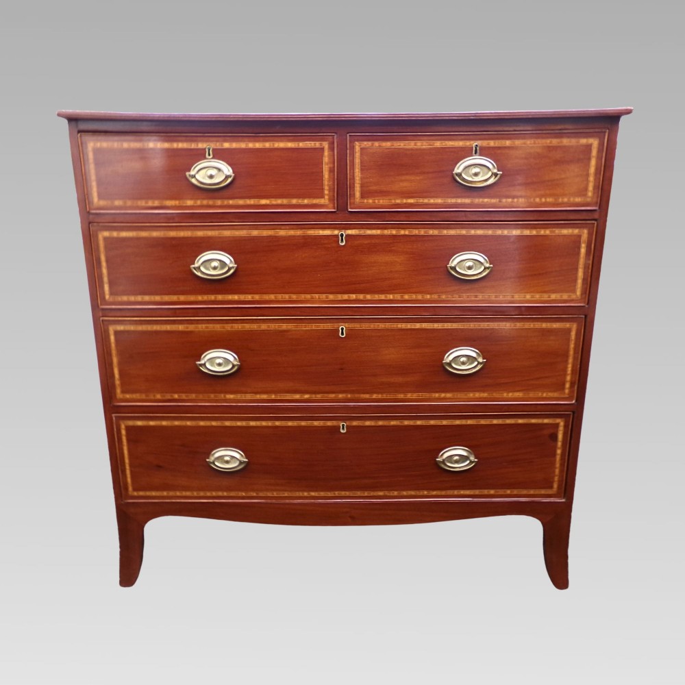 A Victorian mahogany chest of drawers featuring two short over three long drawers with satinwood crossbanding and oval brass handles. View V