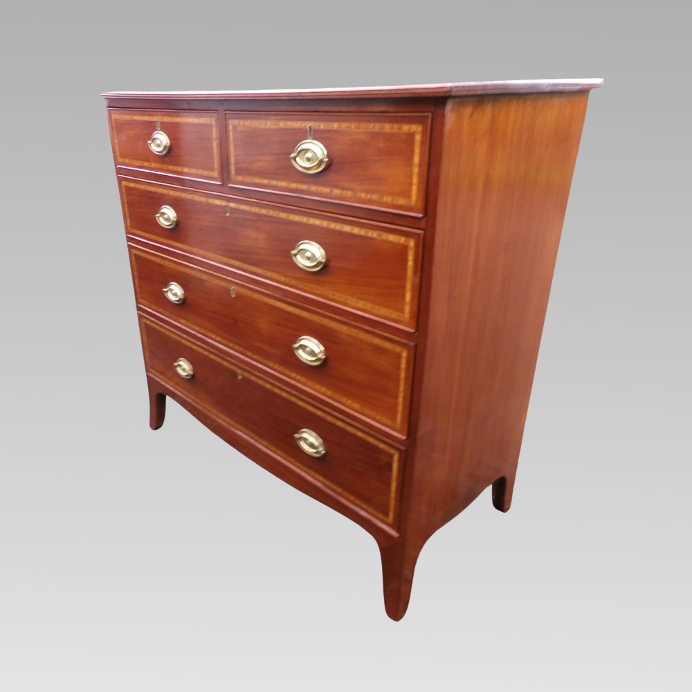 A Victorian mahogany chest of drawers featuring two short over three long drawers with satinwood crossbanding and oval brass handles.