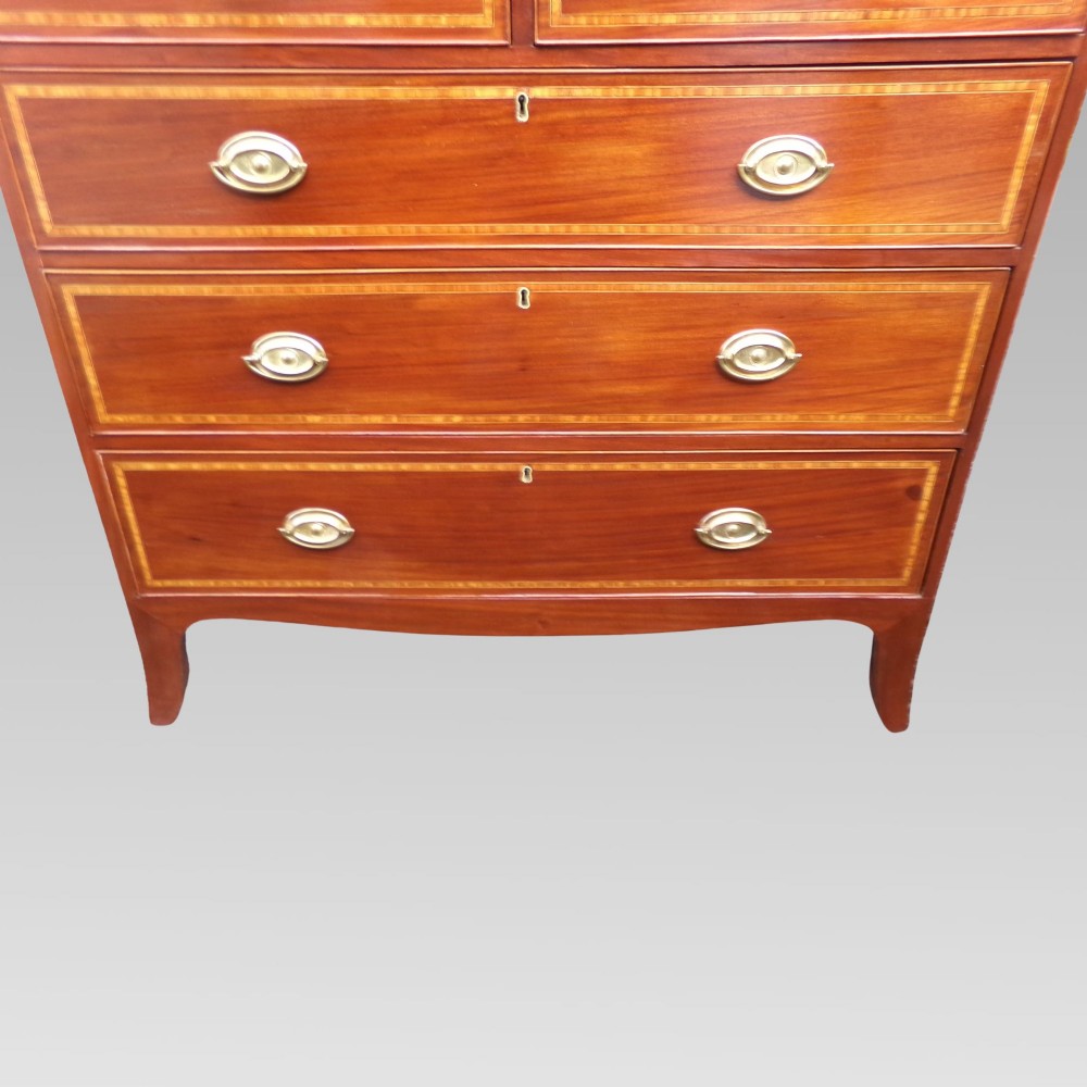 A Victorian mahogany chest of drawers featuring two short over three long drawers with satinwood crossbanding and oval brass handles. View VIII