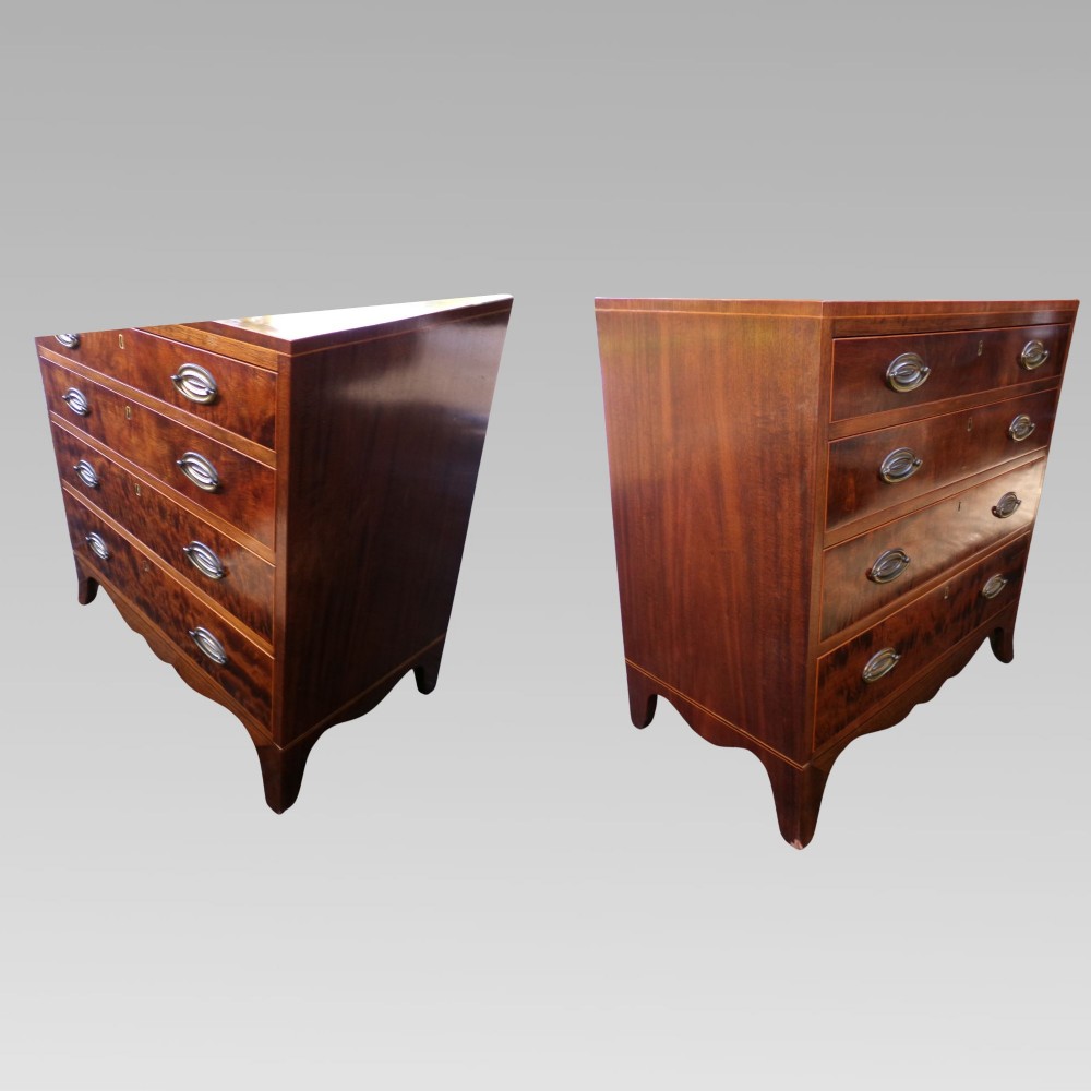 A George III style mahogany chest of four drawers featuring flame mahogany drawer fronts, satinwood line inlay, brass oval handles, and bracket feet. View IV
