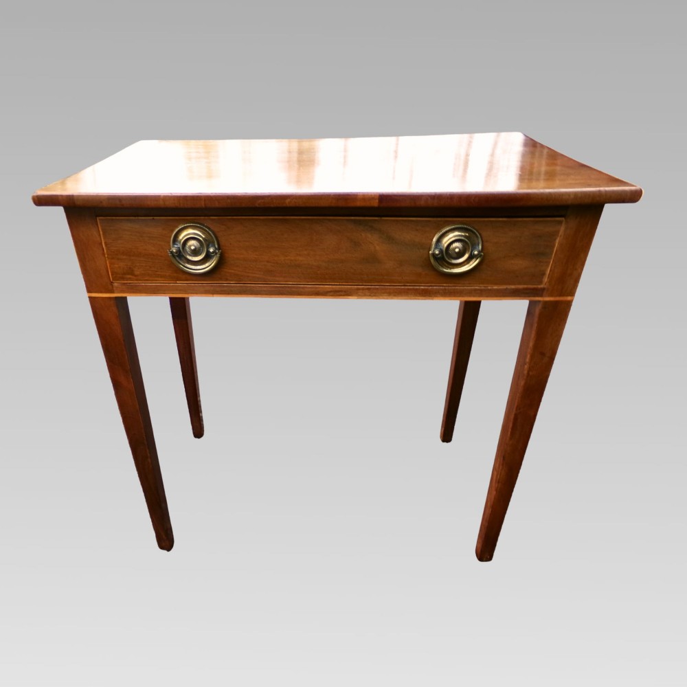 A George III mahogany side table with fine string inlay around the single drawer front and brass ring handles, raised on square tapered legs. View II