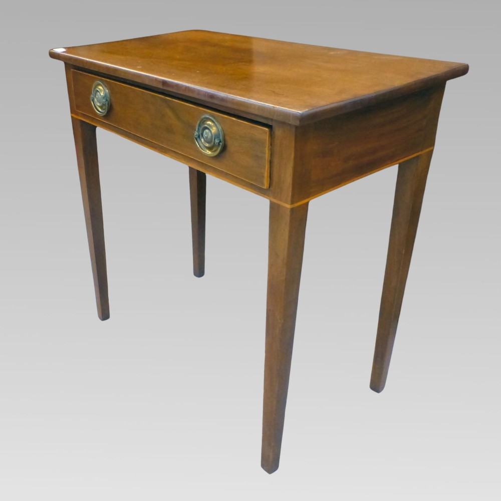 A George III mahogany side table with fine string inlay around the single drawer front and brass ring handles, raised on square tapered legs. View III