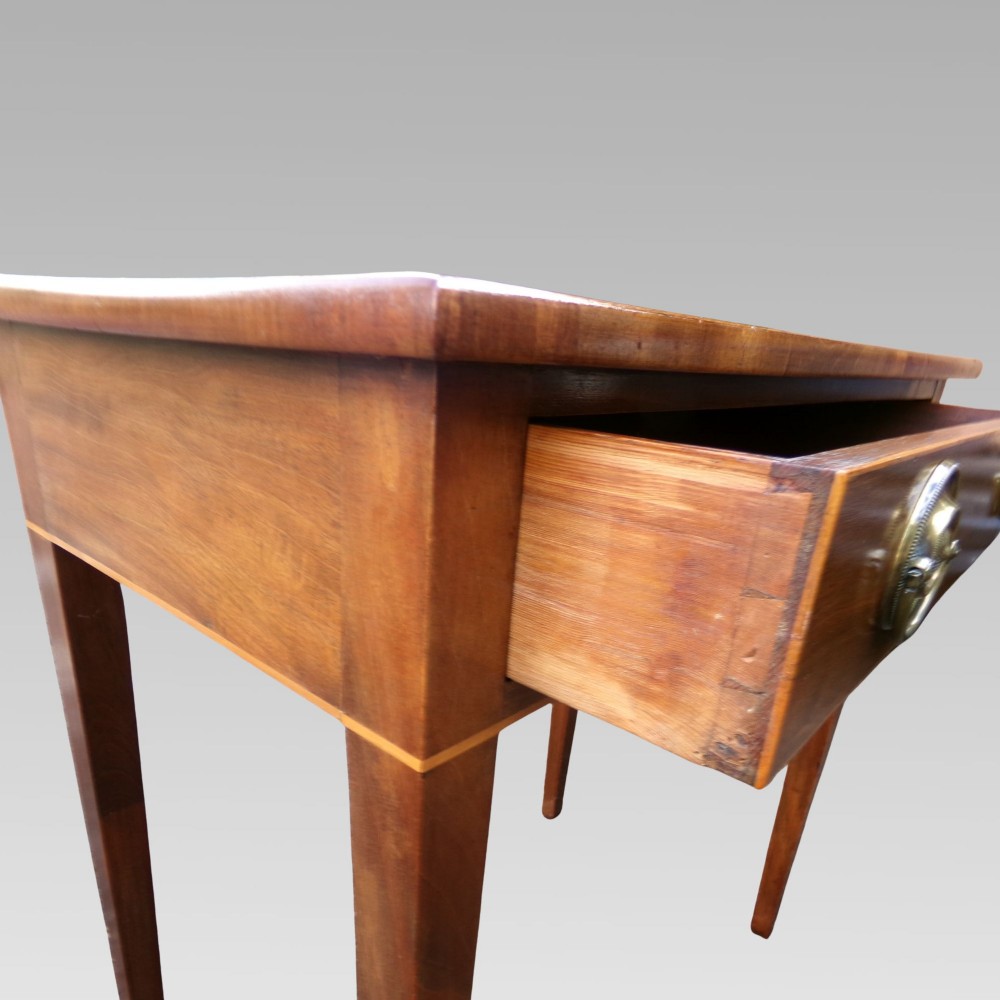 A George III mahogany side table with fine string inlay around the single drawer front and brass ring handles, raised on square tapered legs. View VI