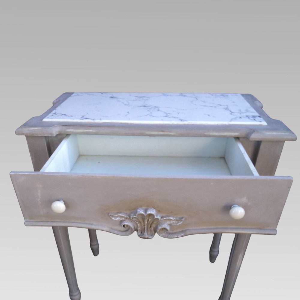 A pair of distressed grey painted French bedside tables featuring white marble inset tops and carved wooden legs. View VI