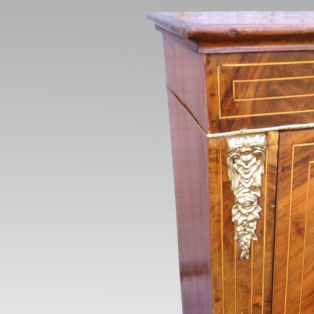 A nineteenth-century walnut veneer pier cabinet featuring floral marquetry inlay, gilt brass mounts, a single glazed door, and a red velvet lined interior. View IV
