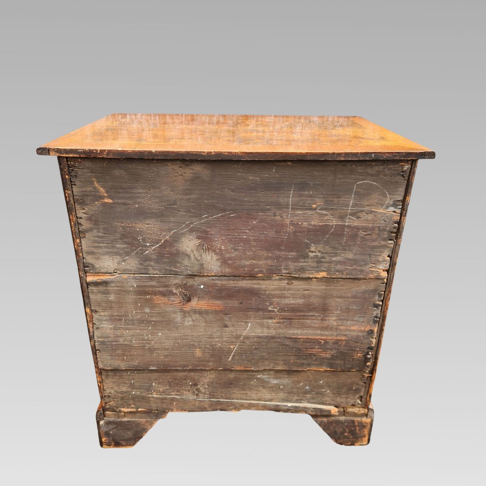 An antique Queen Anne style burr walnut kneehole desk featuring a crossbanded top, brass drop handles, a central recessed cupboard, and bracket feet. View VI