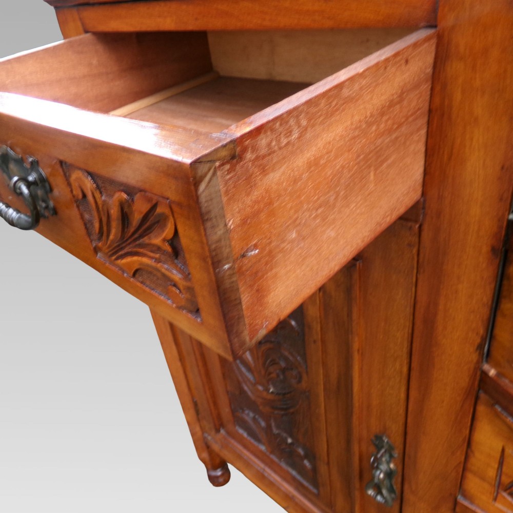 A carved Edwardian mahogany sideboard featuring a bow-front centre section with drawers, flanked by cupboard doors with stylised plant motifs. View IX