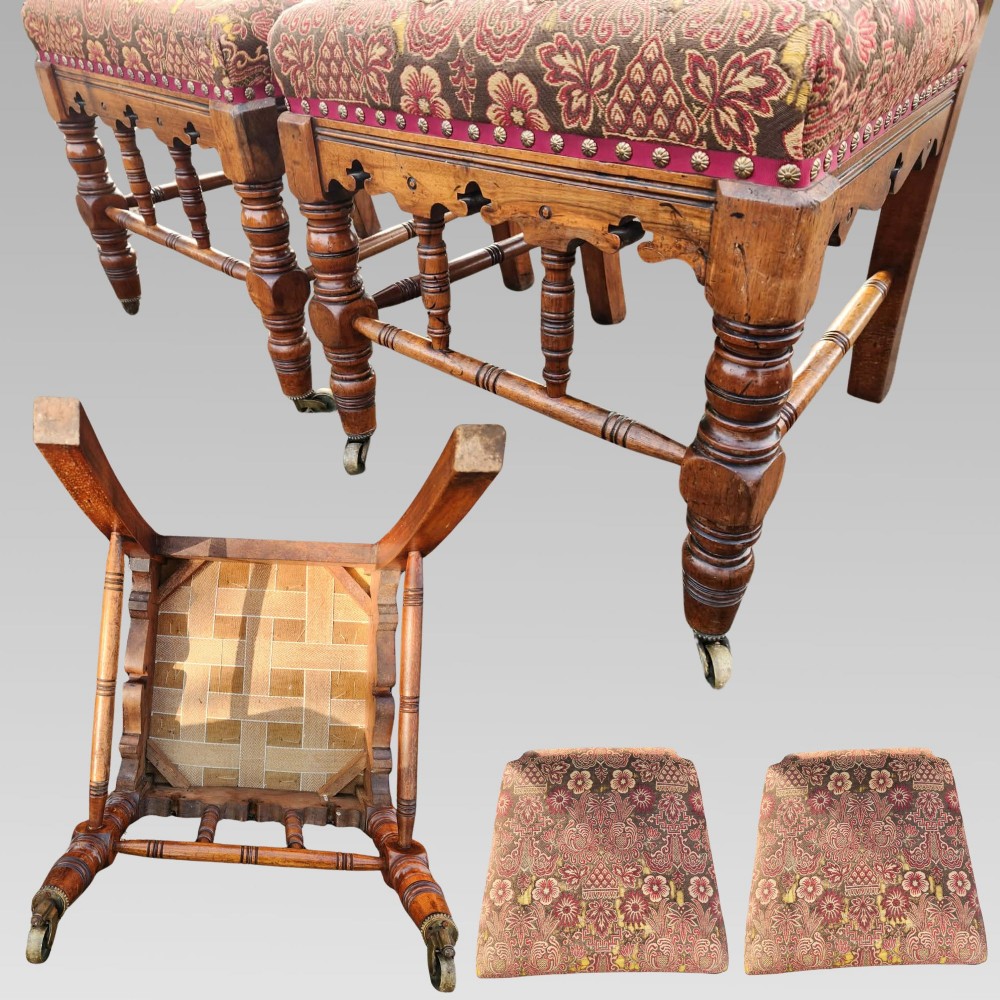 A pair of Victorian Gothic Revival carved oak hall chairs with patterned upholstery and turned legs with brass castors. View VIII