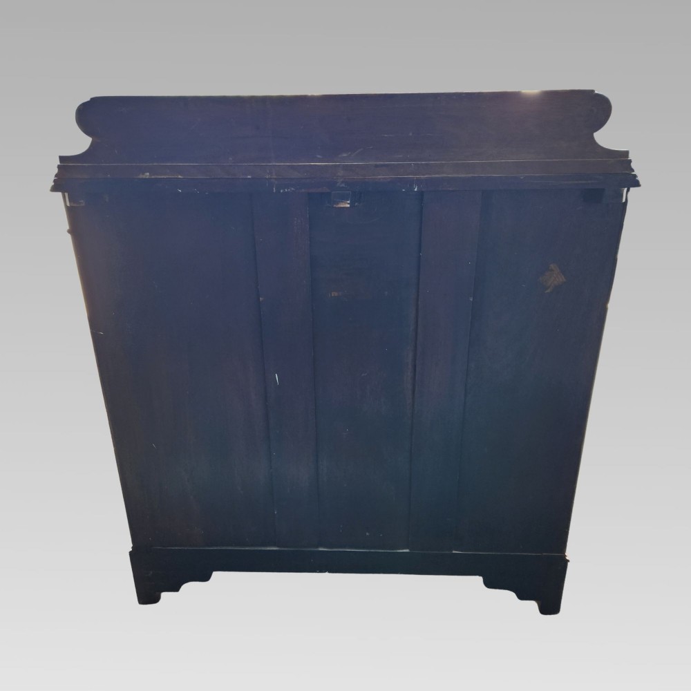 A Victorian mahogany chest of drawers featuring three horizontal drawers with brass handles, a carved wave frieze, and a shaped apron base. View VII