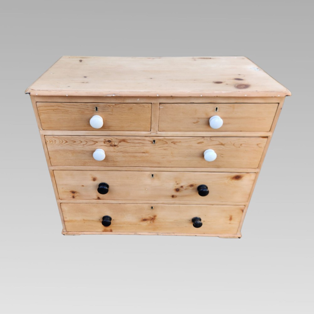 A 19th-century Victorian pine chest of drawers featuring two short over three long drawers with turned white ceramic and black wooden knobs. View IV