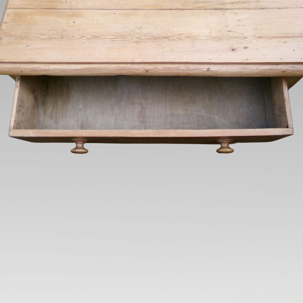 A nineteenth-century Victorian pine chest of drawers featuring three full-width drawers with turned wooden knob handles and a flat plinth base. View V