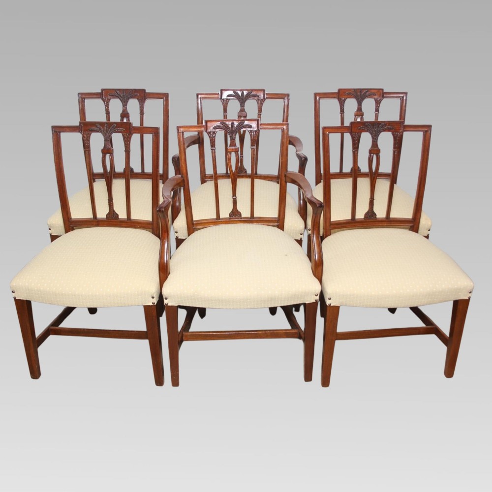 A set of six mahogany Hepplewhite style dining chairs with carved openwork back splats and light cream upholstered seats.