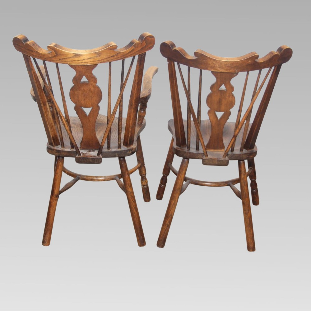 A pair of antique warm brown elm Thames Valley Windsor chairs featuring stick backs, central decorative splats, turned legs, and shaped seats. View III
