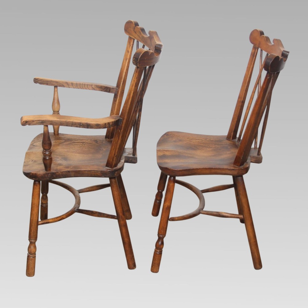 A pair of antique warm brown elm Thames Valley Windsor chairs featuring stick backs, central decorative splats, turned legs, and shaped seats. View IV