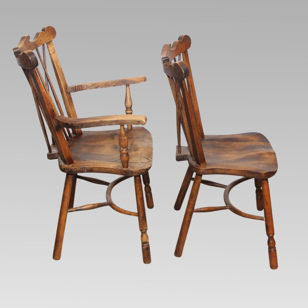 A pair of antique warm brown elm Thames Valley Windsor chairs featuring stick backs, central decorative splats, turned legs, and shaped seats. View V