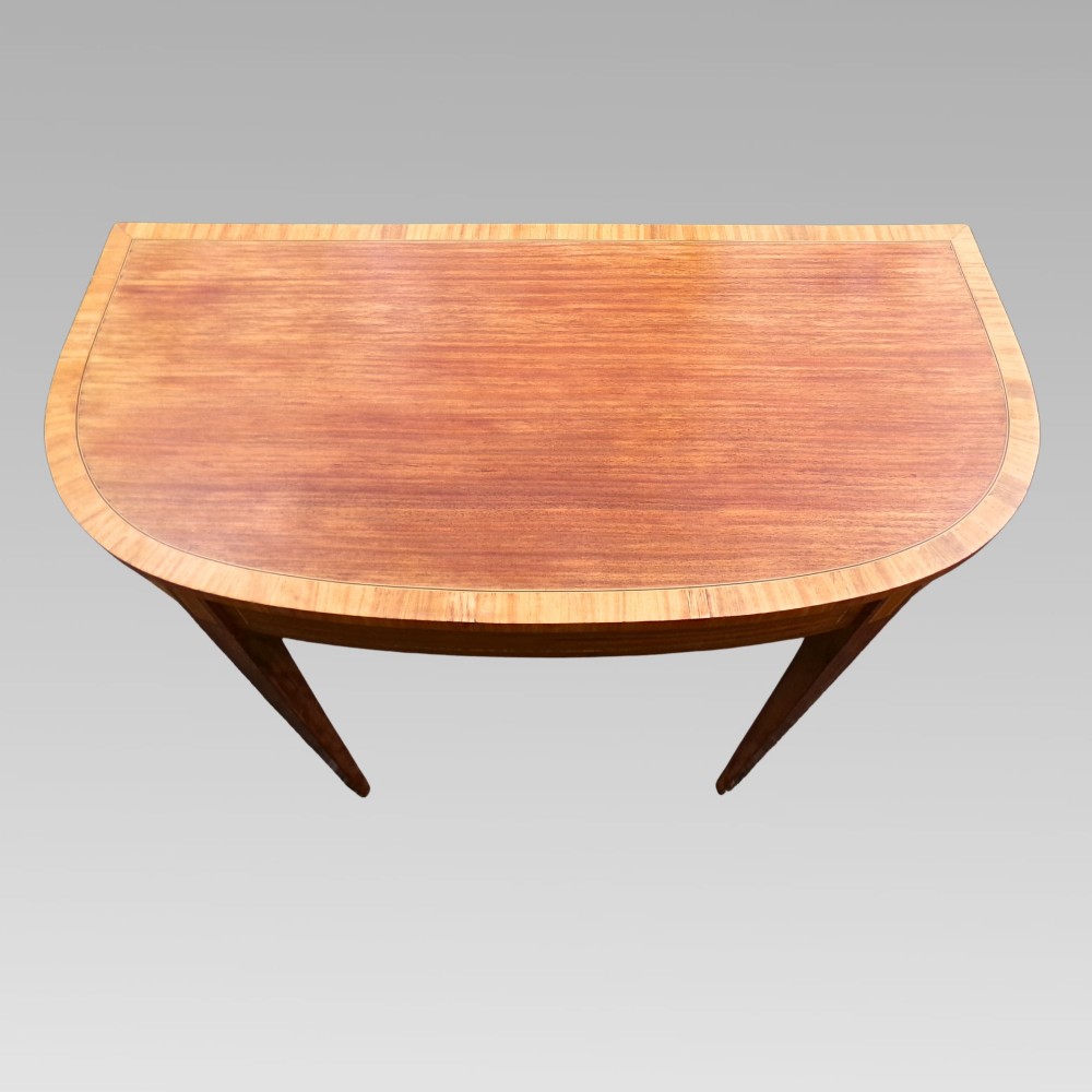 A Georgian style semicircular satinwood console table featuring crossbanded veneer borders and square tapered legs. View II