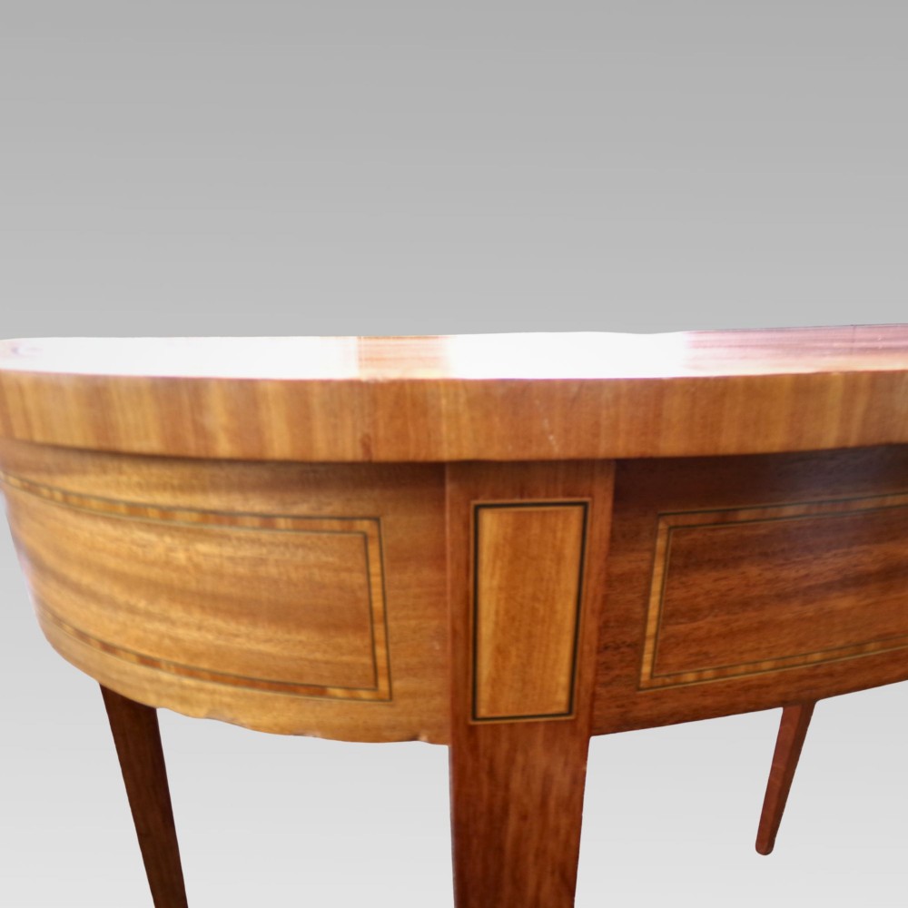 A Georgian style semicircular satinwood console table featuring crossbanded veneer borders and square tapered legs. View IV