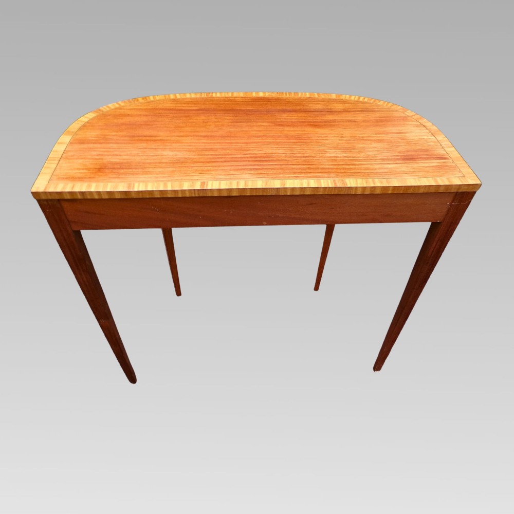 A Georgian style semicircular satinwood console table featuring crossbanded veneer borders and square tapered legs. View IX