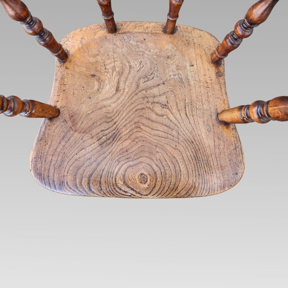 A nineteenth-century turned wood smokers bow armchair featuring a shaped elm seat and turned beech spindles. View V