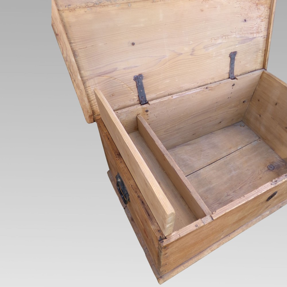 A rectangular nineteenth-century pine blanket box with turned bun feet, side iron drop handles, and a central keyhole escutcheon. View III