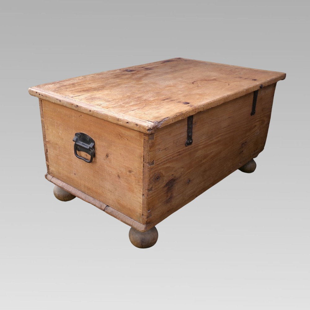 A rectangular nineteenth-century pine blanket box with turned bun feet, side iron drop handles, and a central keyhole escutcheon. View IV