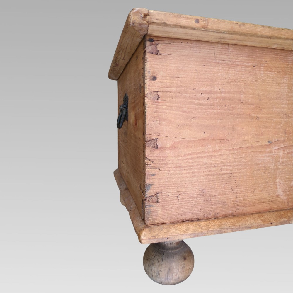 A rectangular nineteenth-century pine blanket box with turned bun feet, side iron drop handles, and a central keyhole escutcheon. View VI
