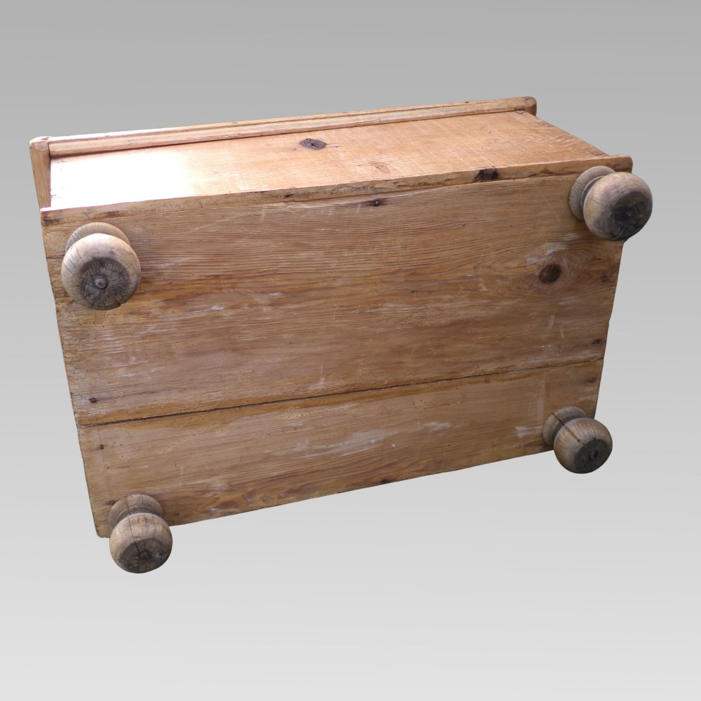 A rectangular nineteenth-century pine blanket box with turned bun feet, side iron drop handles, and a central keyhole escutcheon. View VII