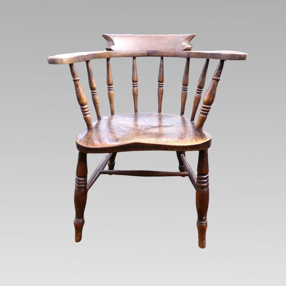 A nineteenth-century elm and beech smokers bow captains armchair featuring turned legs, vertical spindles, and a shaped seat. View III