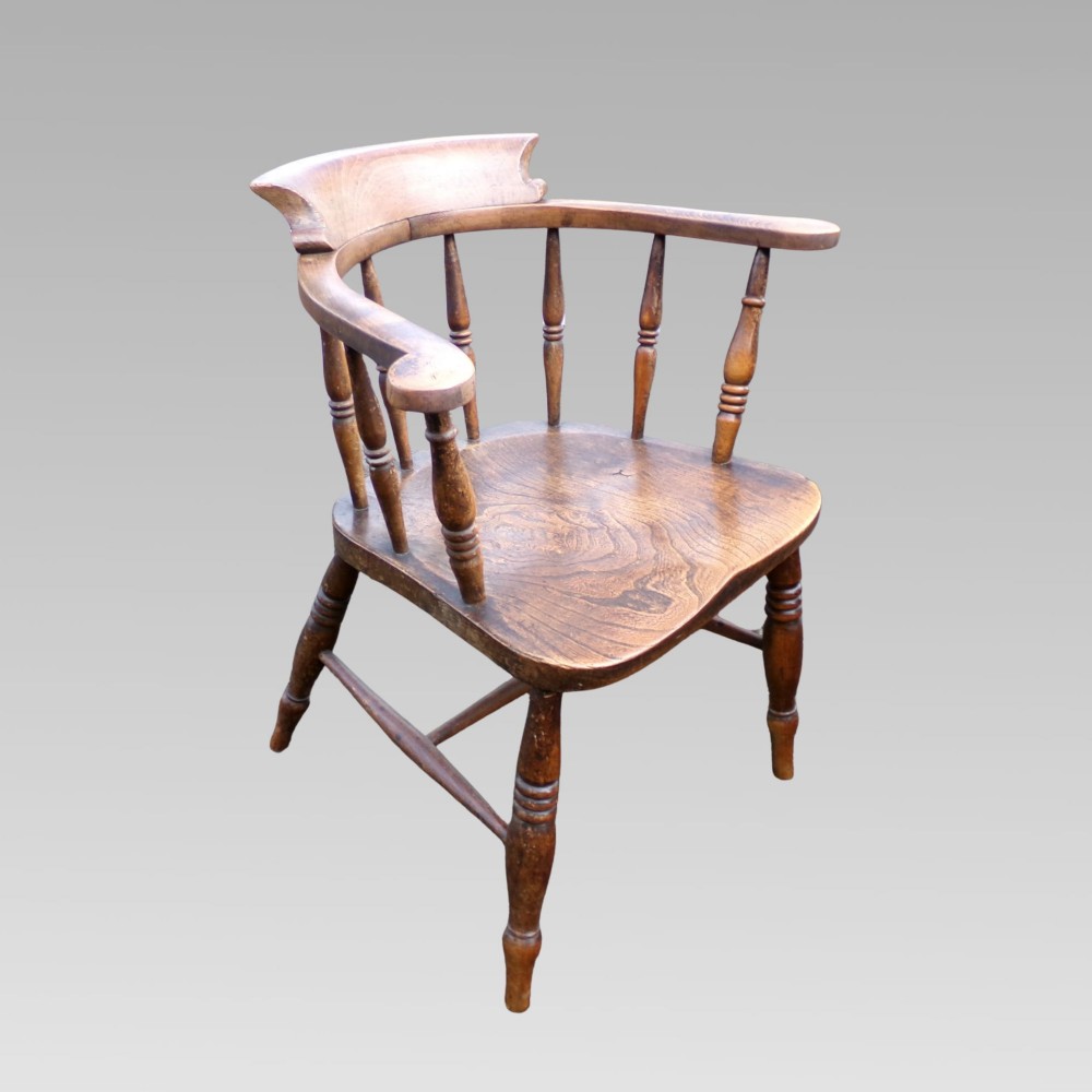 A nineteenth-century elm and beech smokers bow captains armchair featuring turned legs, vertical spindles, and a shaped seat. View IV