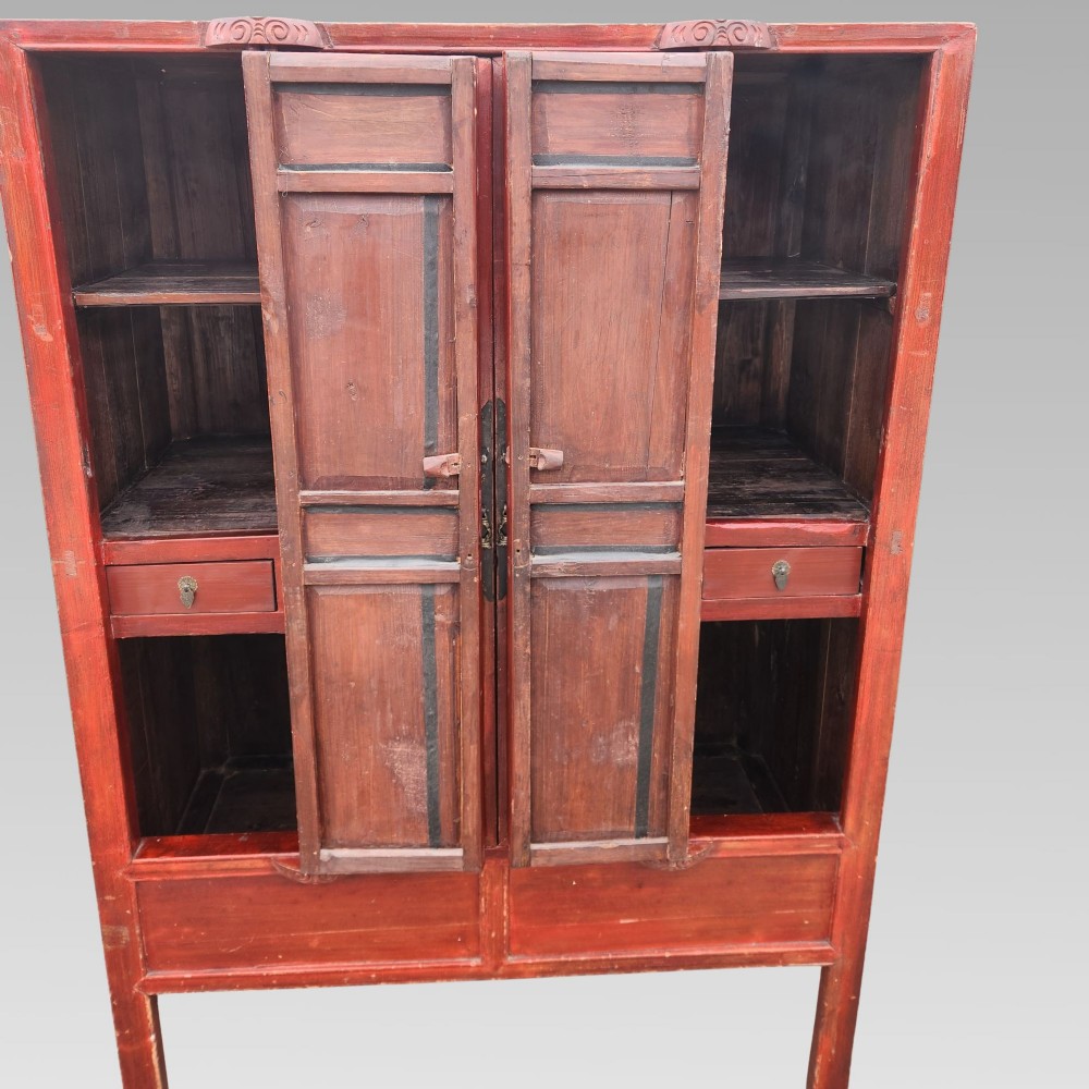 A tall red lacquered Chinese cabinet featuring four vertical doors decorated with hand-painted figurative scenes and floral motifs. View IV