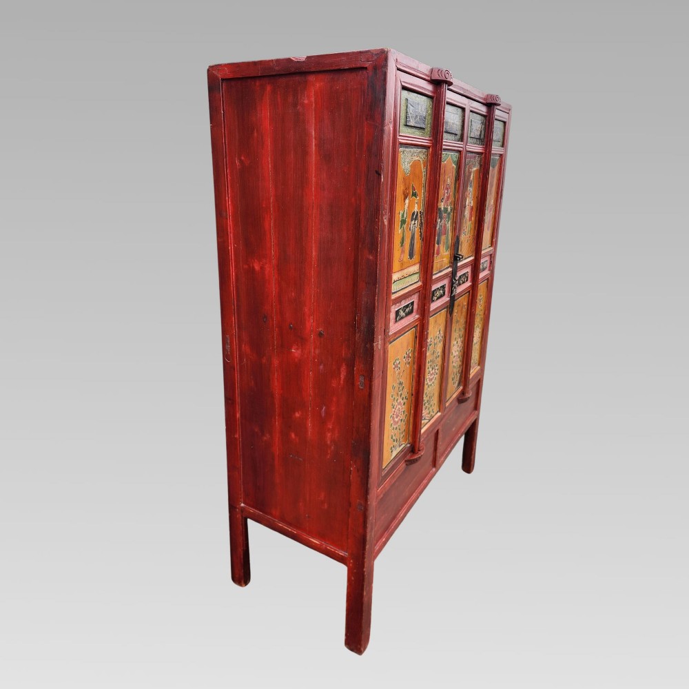 A tall red lacquered Chinese cabinet featuring four vertical doors decorated with hand-painted figurative scenes and floral motifs. View V