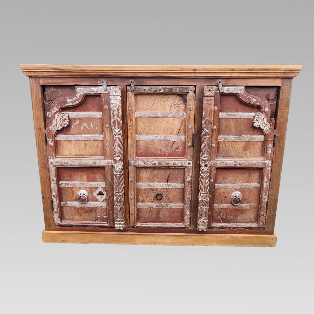 A rustic three-door reclaimed teak sideboard featuring hand-carved floral pilasters, iron ring handles, and metal stud accents. View II