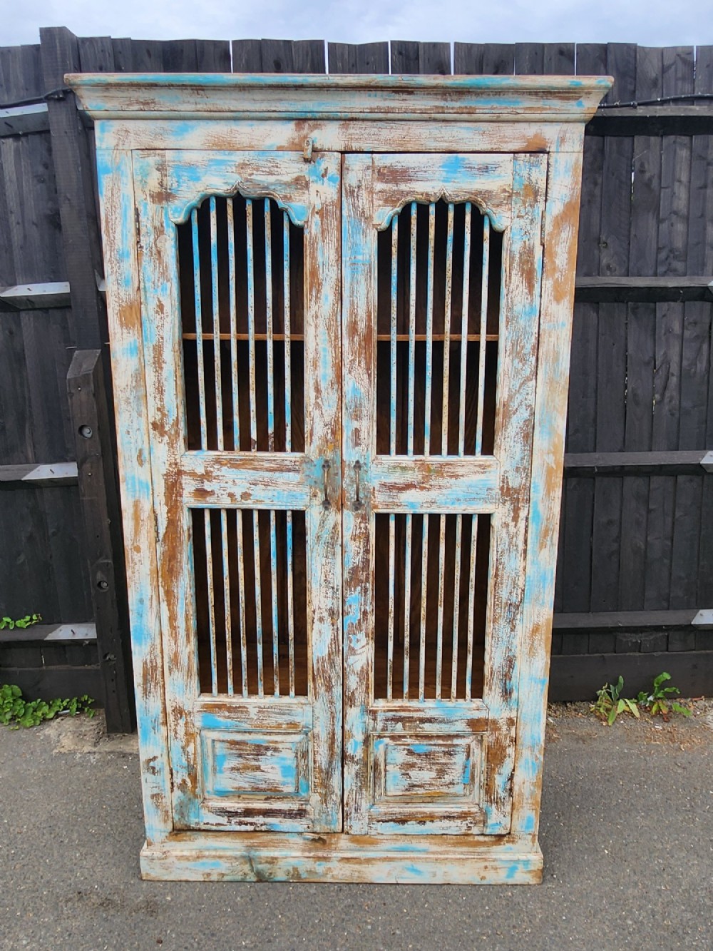 A tall reclaimed teak cupboard featuring two double doors with upper vertical metal slats and a distressed blue and raw timber finish. View II