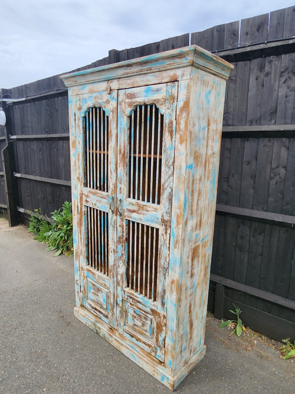 A tall reclaimed teak cupboard featuring two double doors with upper vertical metal slats and a distressed blue and raw timber finish. View III