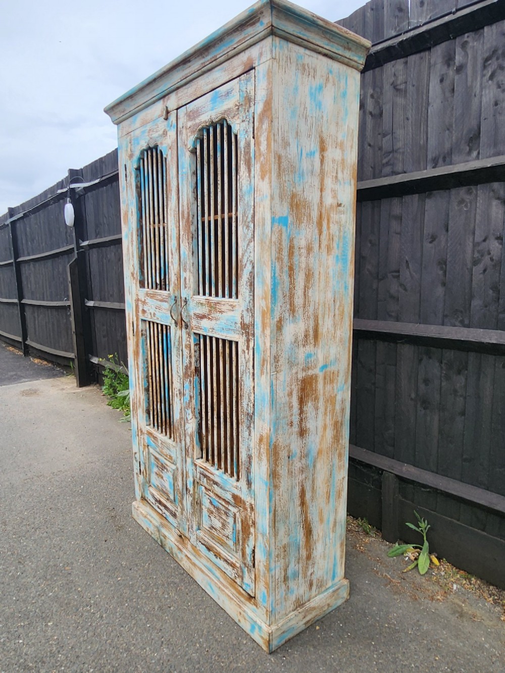 A tall reclaimed teak cupboard featuring two double doors with upper vertical metal slats and a distressed blue and raw timber finish. View IV