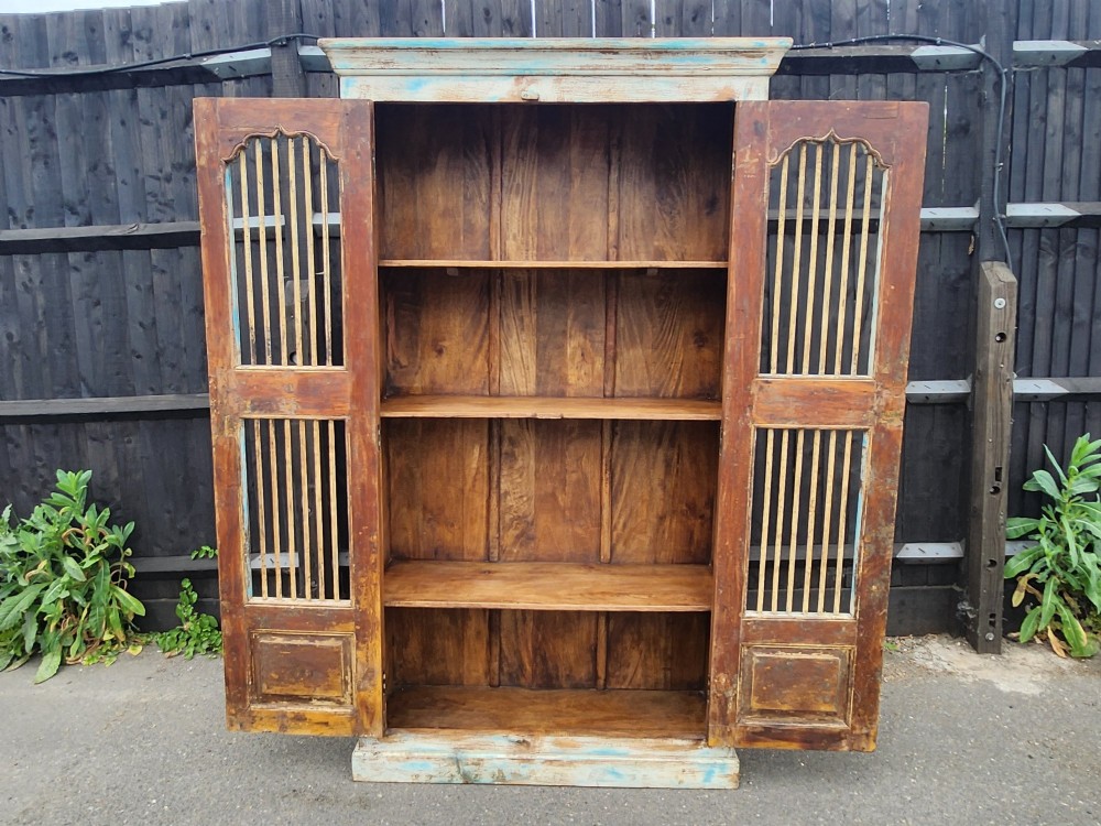 A tall reclaimed teak cupboard featuring two double doors with upper vertical metal slats and a distressed blue and raw timber finish. View V
